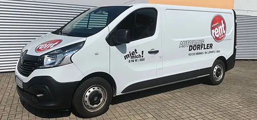 Weißer Renault Trafic Kastenwagen mit „Miet mich!"-Aufschrift vor dem Autohaus Dörfler